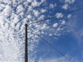 Old electricity wooden pylon and wires with blue cloudy sky Royalty Free Stock Photo