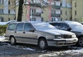 Old veteran dented big hatchback Swedish car silver grey Volvo 850 under snow cover