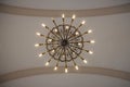 Old, elegant large chandelier hangs from the ceiling of the church dome, filled with energy saving compact fluorescent lights. Royalty Free Stock Photo