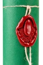 Old elegant red wax seal on a green diploma, certificate tube container, macro, closeup. Retro stylish sealing wax with a string