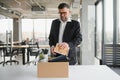 old employee leaving office with the box full of belongings Royalty Free Stock Photo