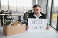 old employee leaving office with the box full of belongings Royalty Free Stock Photo