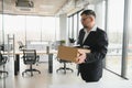 old employee leaving office with the box full of belongings Royalty Free Stock Photo