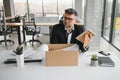 old employee leaving office with the box full of belongings Royalty Free Stock Photo