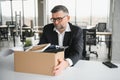 old employee leaving office with the box full of belongings Royalty Free Stock Photo
