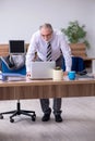 Old male employee suffering from radiculitis at workplace