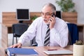 Old male employee suffering from radiculitis at workplace