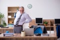 Old male employee suffering from radiculitis at workplace