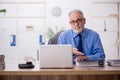 Old male employee working in the office Royalty Free Stock Photo