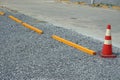 Old empty gravel arking stalls in a parking lot with concrete car stopper and traffic cones Royalty Free Stock Photo