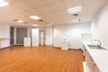 Old empty room with white kitchen furniture and sink that used to serve as office canteen for employees. A spacious and Royalty Free Stock Photo