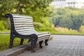 Old empty wooden bench in a shadow of big green tree on bright summer day. Peace, rest, quiet and relaxation concept. Royalty Free Stock Photo