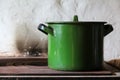 Old enameled green pan saucepan with a lid on a cast-iron stove. rustic cuisine.