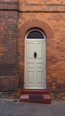 Old English Georgian door set in red brick house with step in front