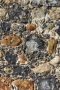 Old English stone town wall surface embedded with ancient flint.