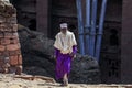 Old Ethiopian Priest in Traditional Clothes going to the Church for pray