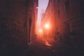 Old European narrow empty street of a medieval town at a foggy evening.