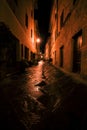 Old European narrow empty street of a medieval town at a foggy evening.