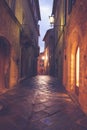 Old European narrow empty street of a medieval town at a foggy evening. Royalty Free Stock Photo
