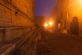 Old European narrow empty street of a medieval town at a foggy evening. Royalty Free Stock Photo