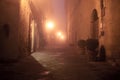 Old European narrow empty street of a medieval town at a foggy evening. Royalty Free Stock Photo