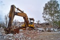 Old excavator on the ruins of an old house. Royalty Free Stock Photo