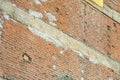 Old exposed brick wall without protective plaster with damaged reinforced concrete