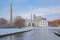 Old factory buildings and chimney along a snow covered park