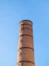 Old factory chimney made of red bricks against blue sky Royalty Free Stock Photo