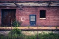 Old factory doors set in brick wall on abandoned loading dock with chainlink fence Royalty Free Stock Photo