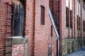 Part of an old factory with brick wall and window and a bent ladder, Royalty Free Stock Photo