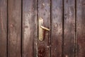 Old, faded classical, brown, wooden door with iron door handle. Door textures and background. Royalty Free Stock Photo