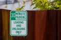 Old faded worn metal 30 minute parking sign with green text Royalty Free Stock Photo