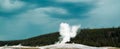 Old Faithful erupting cone geyser in Yellowstone National Park