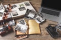 Old family photos and album on wooden background. Vintage pictures, camera, notepad and modern notebook