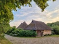 Old farm buildings with thatched roof, beautiful sunset sky Royalty Free Stock Photo