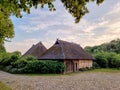 Old farm buildings with thatched roof, beautiful sunset sky Royalty Free Stock Photo
