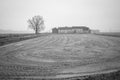 Old farm with its uncultivated field. Black and white photo Royalty Free Stock Photo