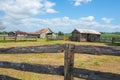 Old farm sheds beyond post and rail fences in rustic rural scene