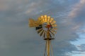 Old farm windmill shining in the golden sunlight at dusk Royalty Free Stock Photo