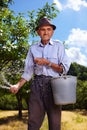 Old farmer fertilizing in an orchard Royalty Free Stock Photo