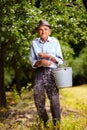 Old farmer fertilizing in an orchard Royalty Free Stock Photo