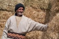 Old farmer man with Hay bales on background. Elderly muslim farmer