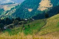 An old farmer's wooden house stands on an elephant mountain near a haystack against the backdrop of mountain peaks Royalty Free Stock Photo