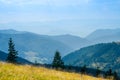 An old farmer's wooden house stands on an elephant mountain near a haystack against the backdrop of mountain peaks Royalty Free Stock Photo