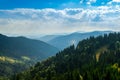 An old farmer's wooden house stands on an elephant mountain near a haystack against the backdrop of mountain peaks Royalty Free Stock Photo