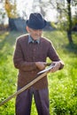 Old farmer sharpening scythe Royalty Free Stock Photo