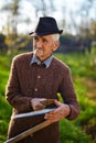 Old farmer sharpening scythe Royalty Free Stock Photo