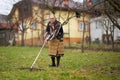 Old farmer woman cleaning with a rake Royalty Free Stock Photo