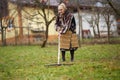 Old farmer woman cleaning with a rake Royalty Free Stock Photo